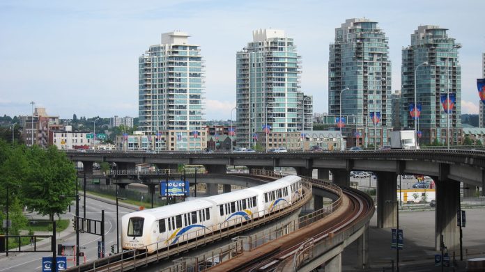 A photo of an elevated metro line with modern towers in the background.