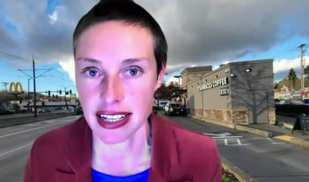 Woman with short hair in front of a digital photo of a drive thru Starbucks with cars waiting