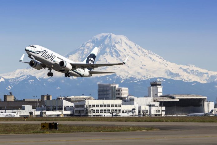 Alaska Airlines plane takes off from Seattle-Tacoma International Airport with Mt. Rainier in the background.