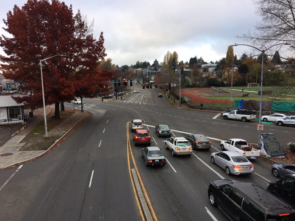 A massive intersection where two six lane streets come together at an angle. One side of the intersection is missing a marked crosswalk.