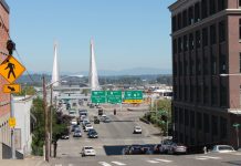 Tacoma Seeks Input for Vision Zero Safe Streets Action Plan A photo of an crosswalk on a wide street with street signs and a bridge in the distance.