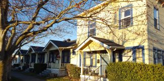 a photo of a small apartment building next to cottages