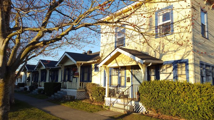 a photo of a small apartment building next to cottages