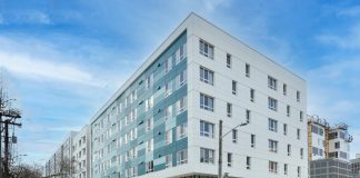 a photo of a modern aqua and white five story apartment building