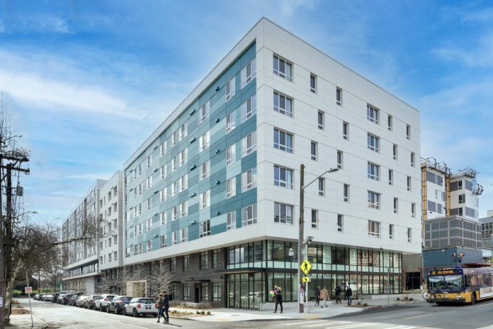 a photo of a modern aqua and white five story apartment building