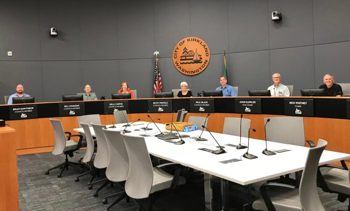 A photo of people sitting in a city council chamber.