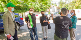 A photo of people standing in a circle in a parking lot