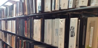 A photo of books on a library shelves.