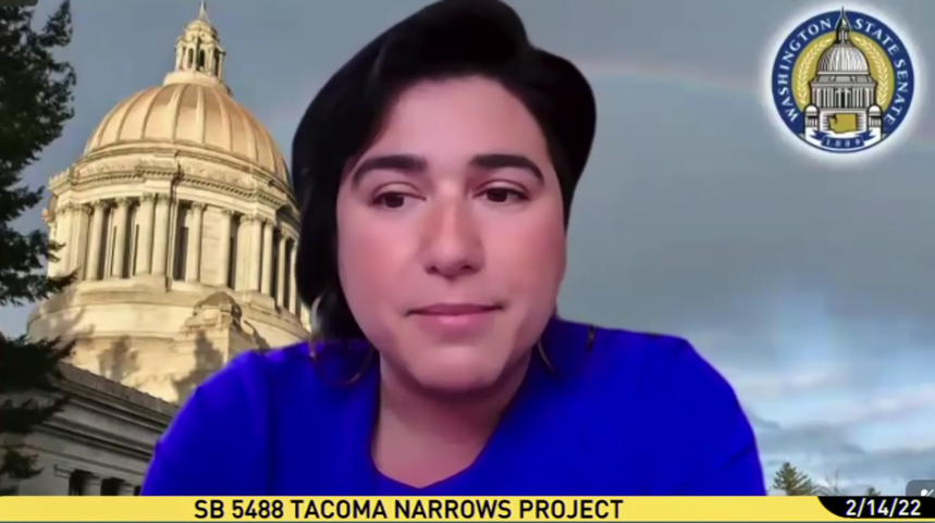 Female presenting lawmaker in front of digital image of Washington state capital with label for SB 5488