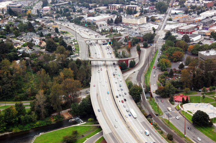 A photo of a wide highway in a suburban landscape.