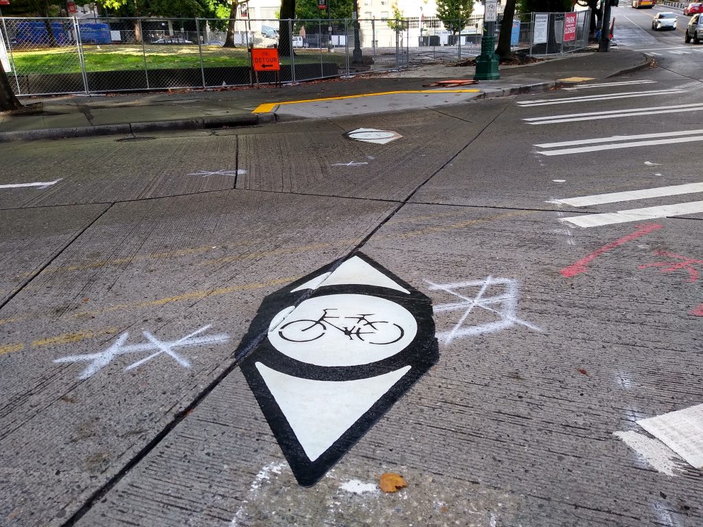 Crosswalk with adjacent bike symbols and cutout on sidewalk for bikes