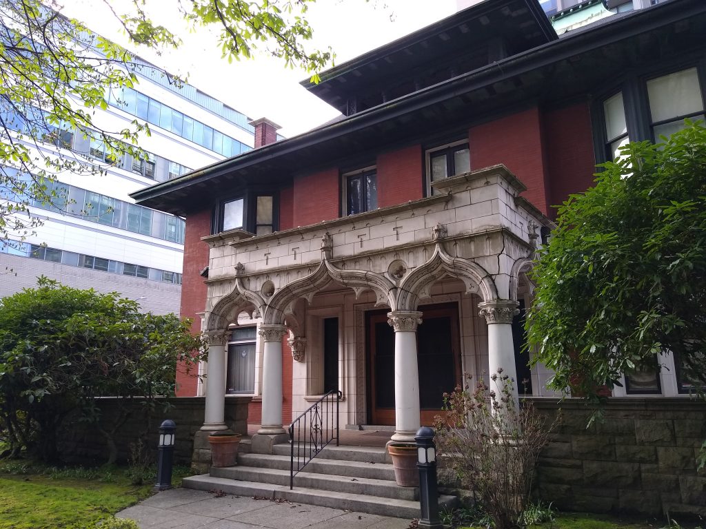 A photo of a historic brick home with white pillars. 