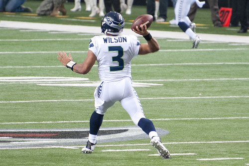 A photo of a football player running with the ball.