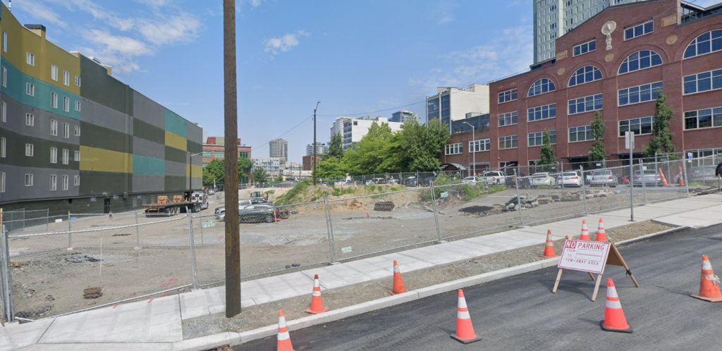 Lot behind fence with new sidewalk