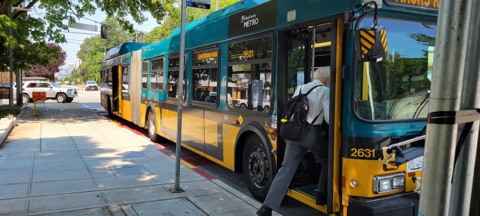 A man board an articulated bus.