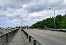 Plans Advance for a Safe Bike Route Between SoDo and Georgetown A photo of a narrow sidewalk separated from a roadway by a metal rail.