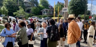 a photo of a group of people standing and talking in the sun