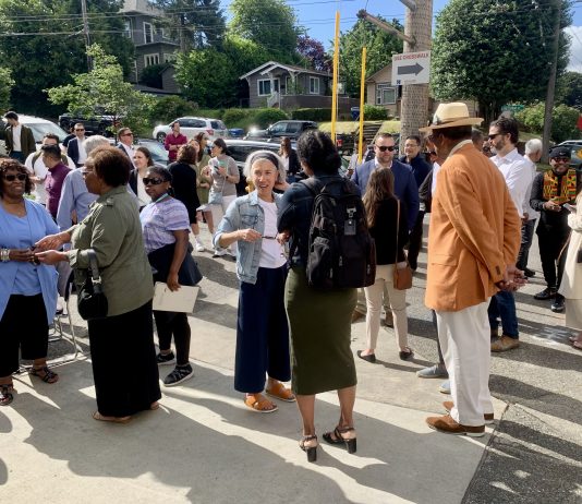 Housing Notes: Amazon Invests in Affordable Housing, Social Housing Goes to Ballot, JumpStart Tax Wins Legal Challenge a photo of a group of people standing and talking in the sun