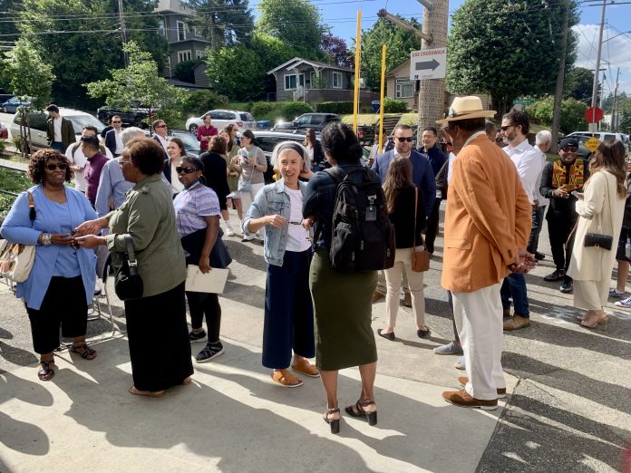 a photo of a group of people standing and talking in the sun