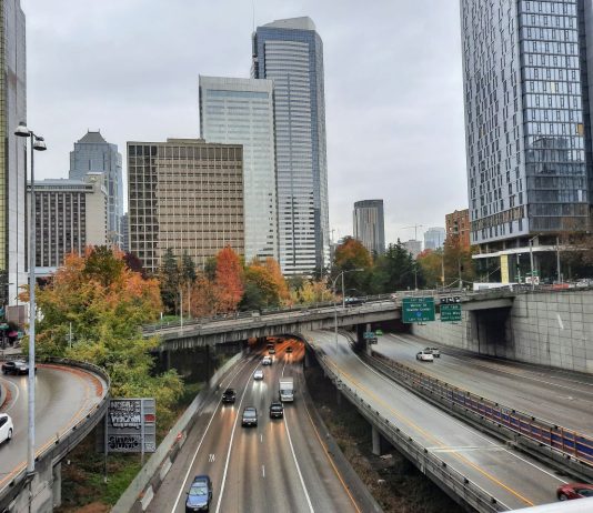 Ridehailing Sees Bigger Ridership Dip than Transit in Seattle I-t trench with skyscapers and overpasses in the background.