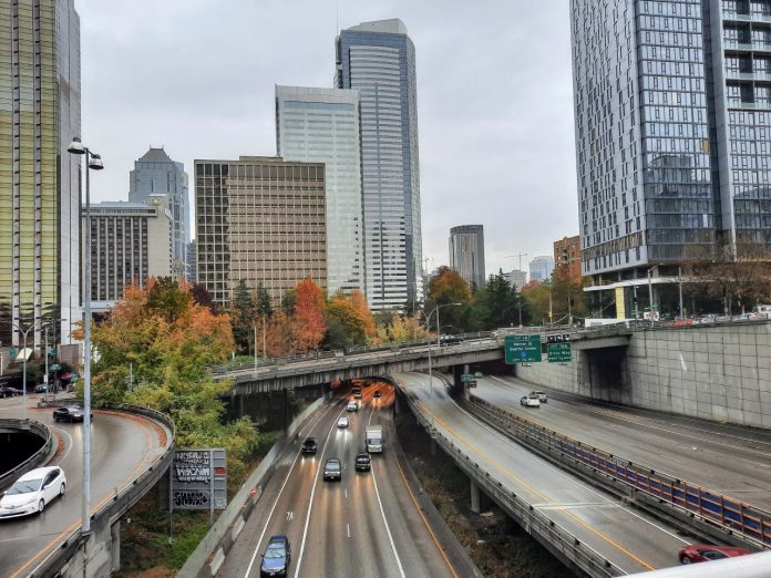 I-t trench with skyscapers and overpasses in the background.