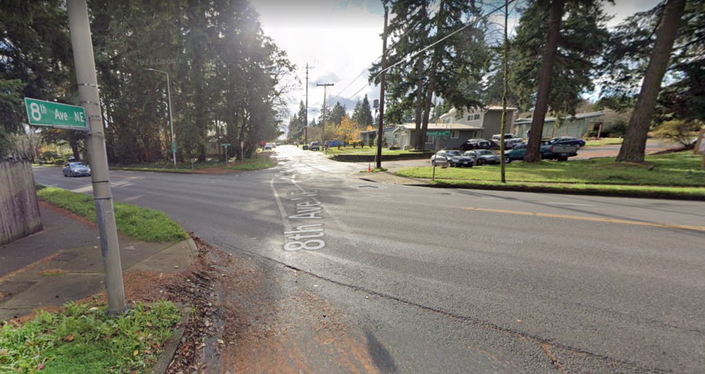 An image of an offset intersection with no traffic controls. 8th Ave NE runs north south with Roosevelt Way NE running diagonally through it