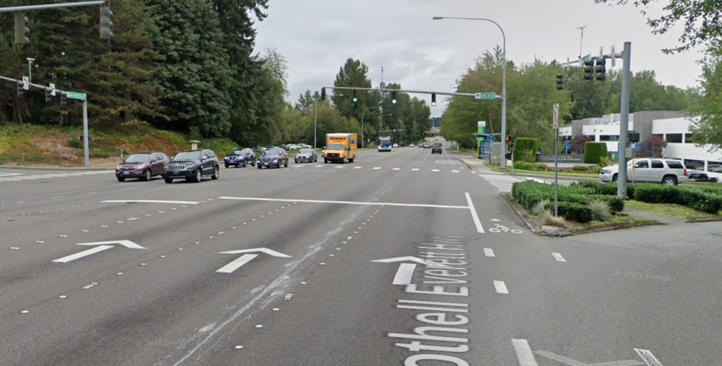 A massive road with seven or eight lanes and a tiny paint bike lane