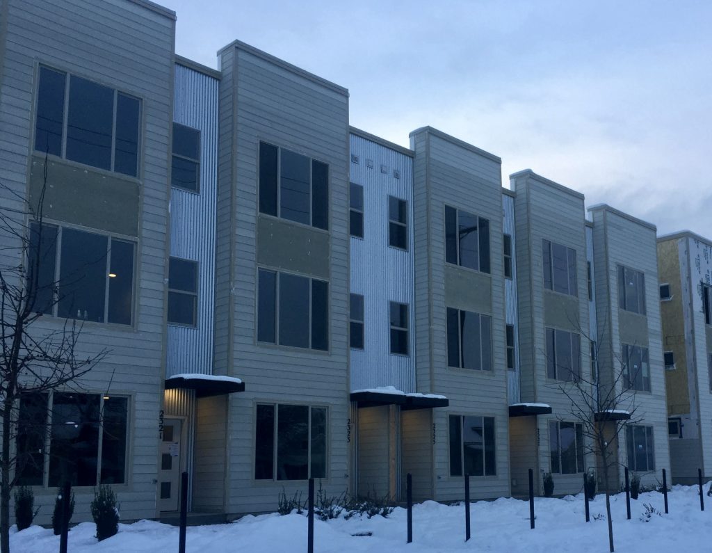 White and beige modern row houses in the snow.