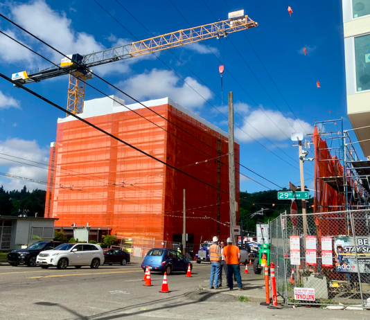 Housing Abundance and Affordability Social Hour with Tech 4 Housing A construction crane over a building under construction with another building under construction across the street and workers standing between them.
