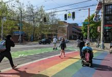 The Seattle Transportation Plan Must Be Bold people walk and roll across a rainbow painted crosswalk