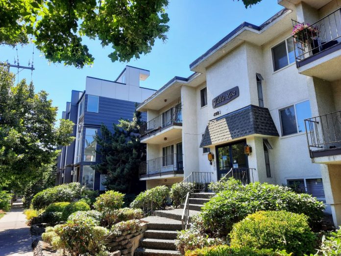 A three-story apartment building next to a three-story townhome complex on leafy California Avenue in West Seattle.