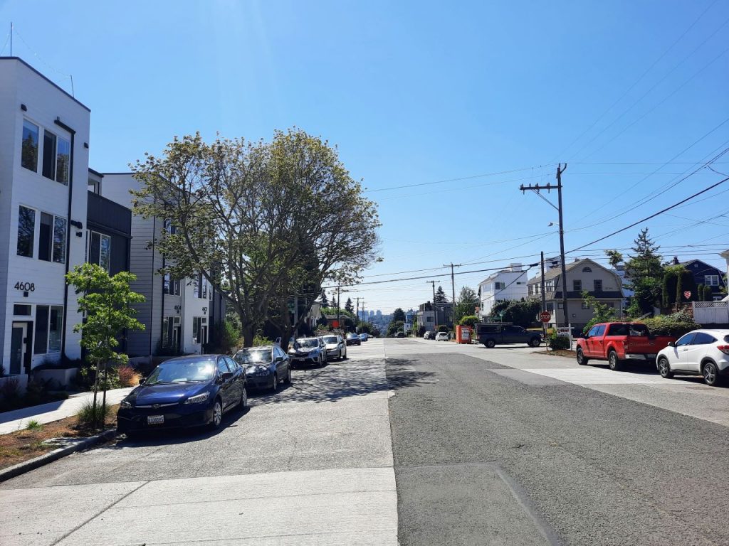 A wide empty asphalt paved street with parking on both sides.