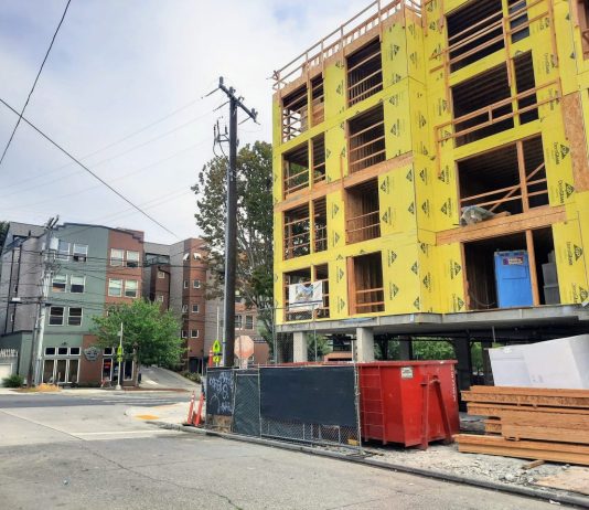 Chamber Poll Finds Strong Support for Housing, Zoning Reform among Seattle Voters A five story building with yellow insulation before siding is added.