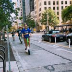 Scooter riders on a protected bike lane downtown