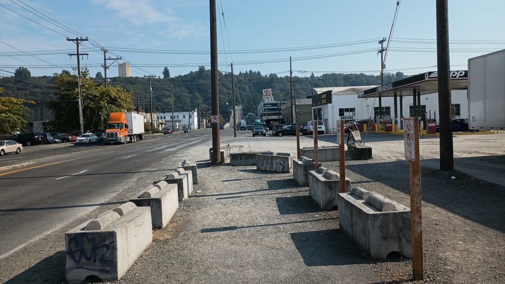 A missing sidewalk along Holgate with eco blocks protecting a walking path