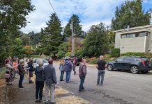A Reflection on the “Forbidden Houses” of Bothell A photo of a group of people standing in the street in front of a small multi-family home.