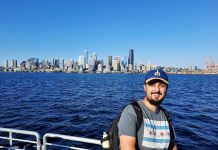 Spring Member Drive: We’ve Come a Long Way in 10 Years Rian Watt, pictured here with Elliott Bay and the Seattle Skyline. He wears a Mariners hat.
