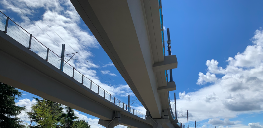 Curving, parallel concrete overpasses against a blue sky.