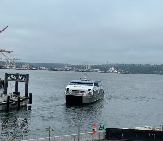 West Seattle Water Taxi To Maintain Summer Service Levels Year-Round Elliott Bay view of a water taxi arriving at Colman Dock downtown Seattle on a very cloudy day.