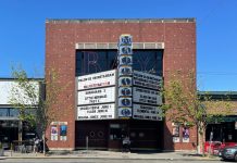Your 2023 Urbanist Summer Movie List Street scape brick facade movie theater building in front of a blue sky featuring a marquee advertising Majestic Bay, Guardians 3, Little Mermaid, Fast X and coming attractions of Indiana Jones and Spiderverse.