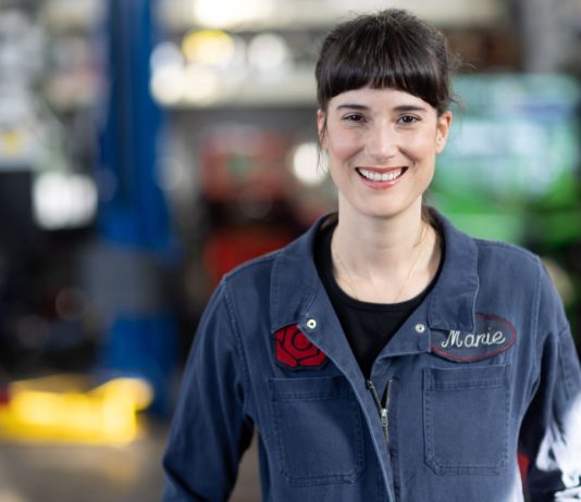 Five Takeaways from the 2022 Election A young dark-haired woman in her blue autobody shop overalls.