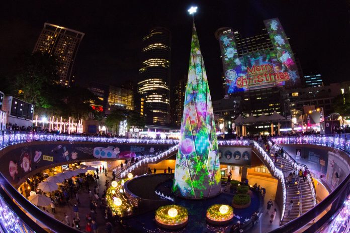 Brightly colored Christmas lights and a Christmas tree in the center of a transit station.