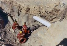 Join for Permitting Impediments Forum on April 26 Trench cut in dirt with an intersection of iron pipes and a lightly colored stormwater crossing.