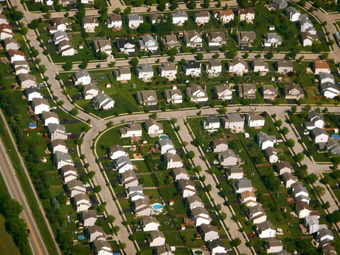 An aerial shot of cookie cutter houses in a subdivision.