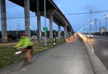 Op-Ed: Vote Yes on Seattle Prop 1 to Save Lives The low bridge stands at dusk with the high bridge above it, and a cyclist is coming off the bridge and is blurred by motion