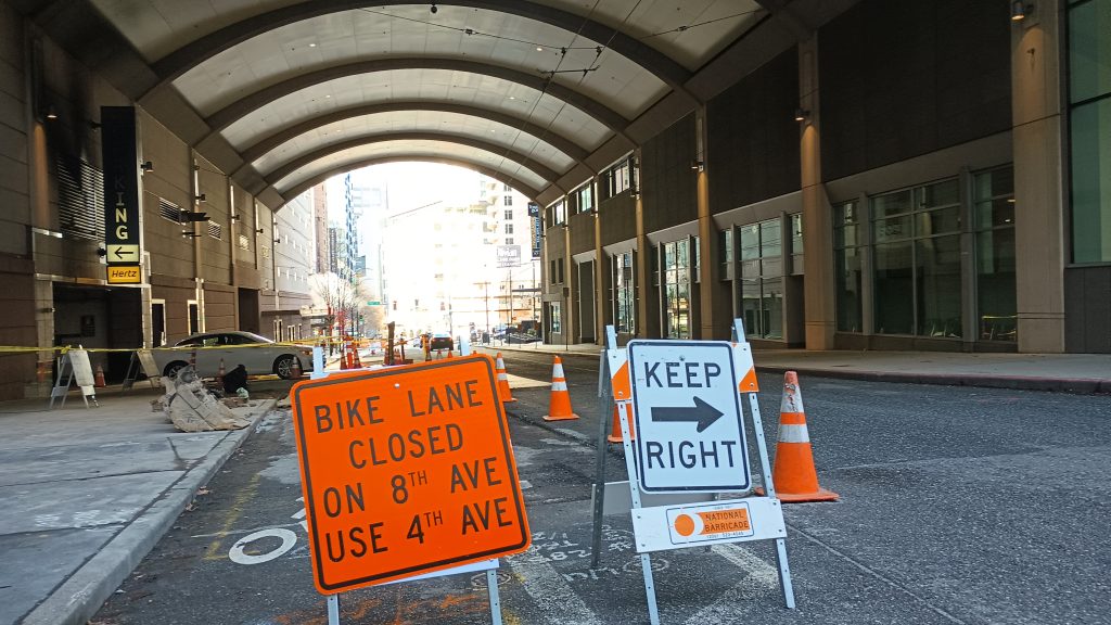 A sign reading "Bike Lane Closed on 8th Ave use 4th Ave" and "keep right"