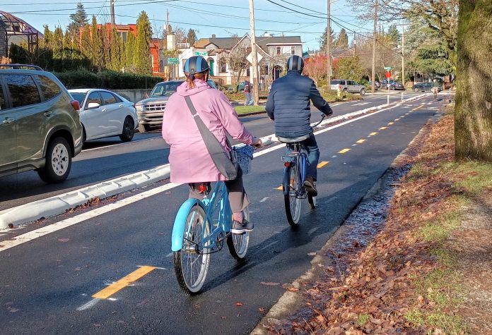 Two people biking on the Green Lake Outer loop where a vehicle lane used to be