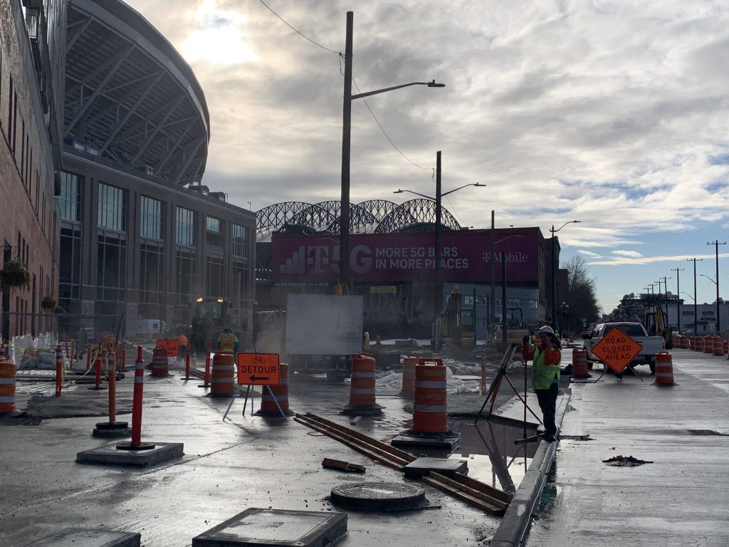 Road construction in front of a stadium.