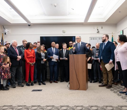 State Road Safety Push Overlooks Design, Dwells on Enforcement Governor Inslee stood at the podium at the Captiol with dozens of legislators and stakeholders behind him.