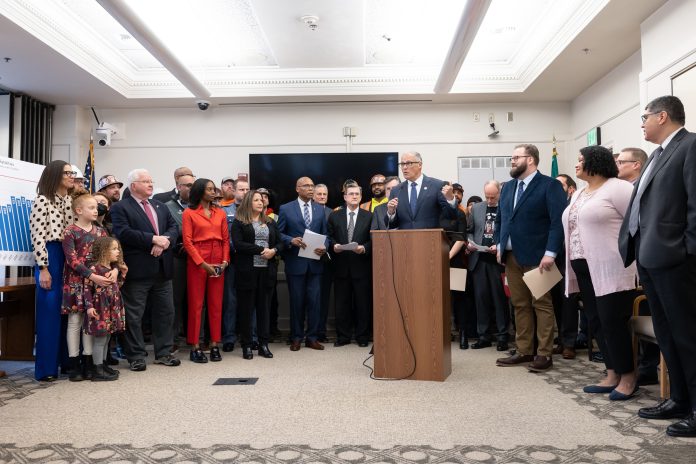 Inslee at Traffic Safety press conference - via Liias Office Governor Inslee stood at the podium at the Captiol with dozens of legislators and stakeholders behind him.